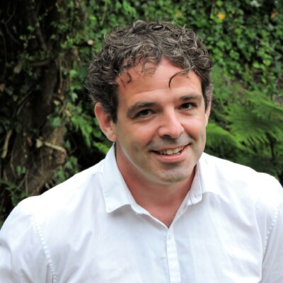 Photo of Eoghan Walls standing outside and smiling at the camera.