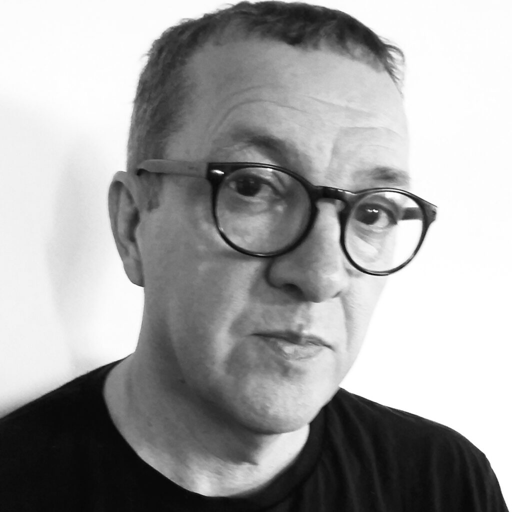 Black and white photo of Euron Griffith, a white man with short dark hair. He is wearing a dark t-shirt and glasses.