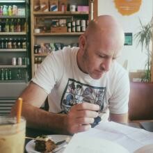Photo Glyn Edwards working at a coffee shop table.