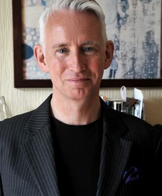 Graham Davies is a white man with short hair. He is wearing a dark t-shirt and jacket.