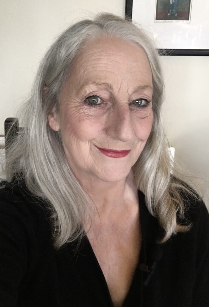 Photo of Jo Mazelis. She is smiling at the camera and is wearing a black top.
