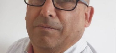 Colour photo of Michael O'Brien. He is wearing a white shirt and glasses.