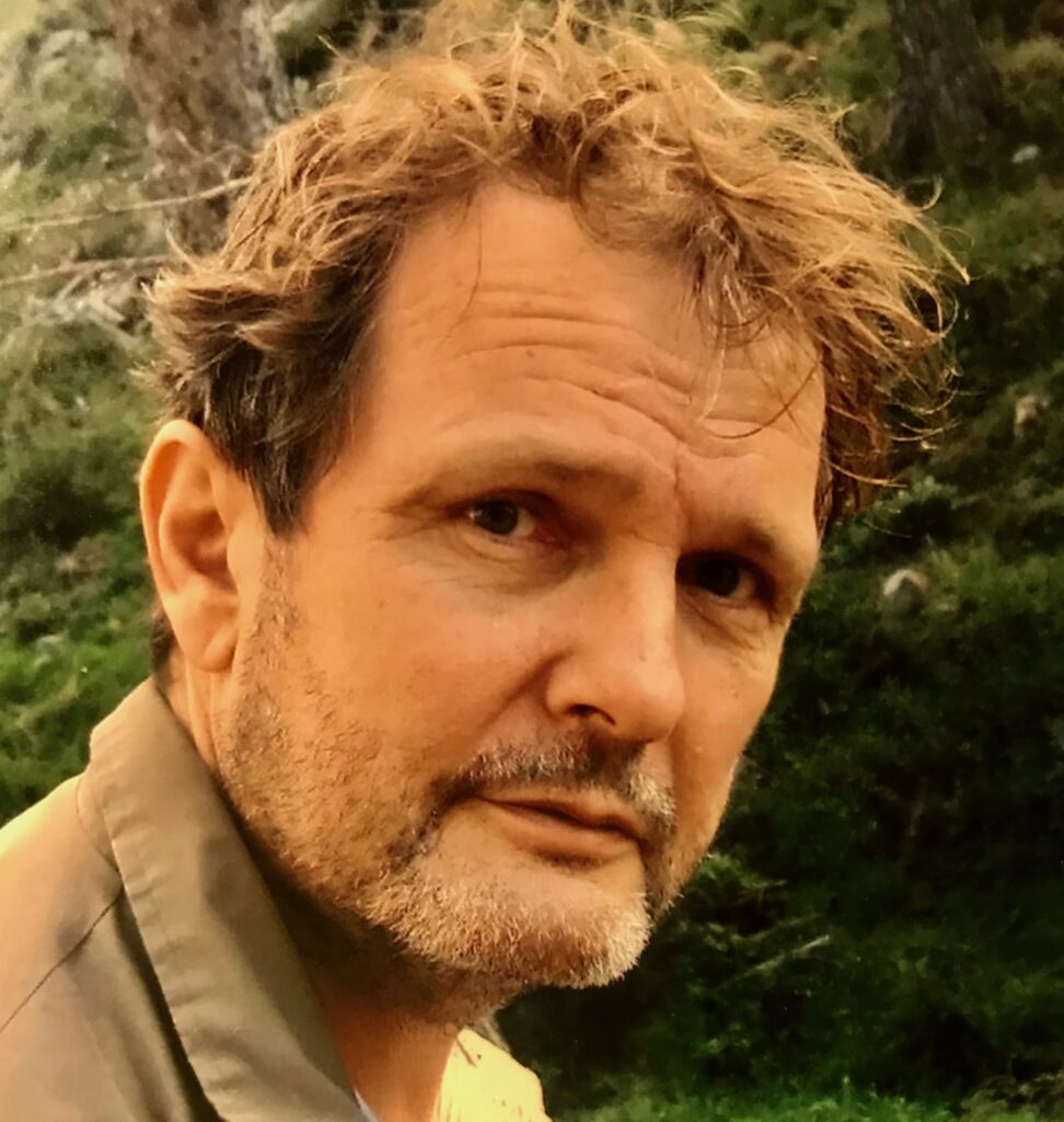 Richard Gwyn is a white man with short brown hair. He is looking over his shoulder towards the camera.