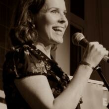 Photo of Rhian Edwards reading at an event with a microphone