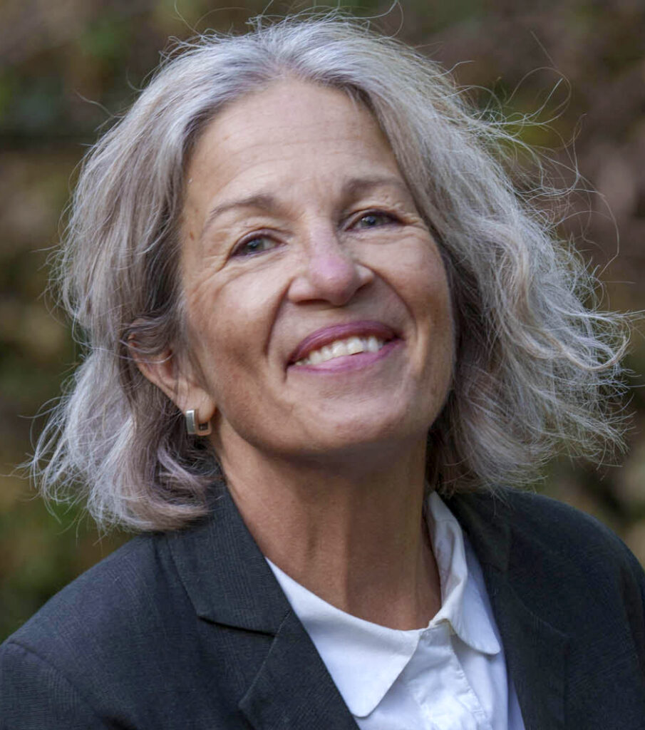 Photo of Vanessa Lampert. She is smiling broadly at the camera and has short grey hair.