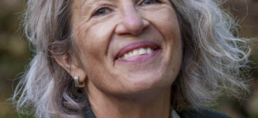 Photo of Vanessa Lampert. She is smiling broadly at the camera and has short grey hair.
