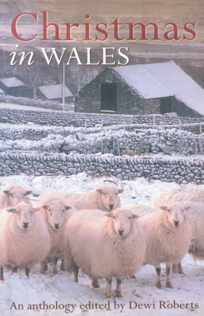 This cover shows a small number of sheep in the foreground. Behind the sheep is a snowy farmhouse. The text reads: Christmas in Wales. An Anthology edited by Dewi Roberts.