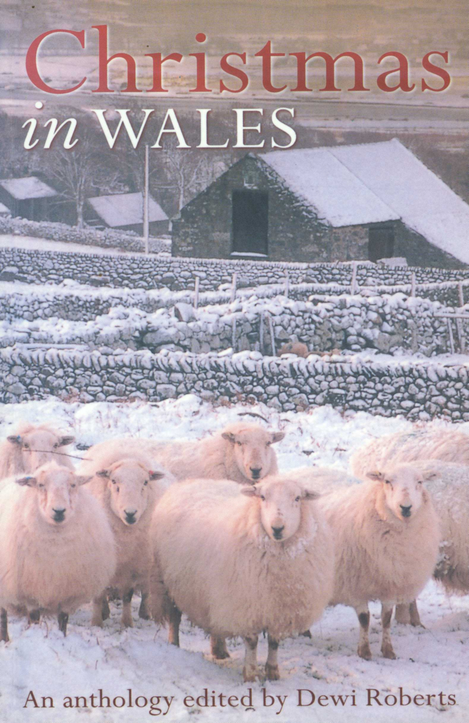 This cover shows a small number of sheep in the foreground. Behind the sheep is a snowy farmhouse. The text reads: Christmas in Wales. An Anthology edited by Dewi Roberts.