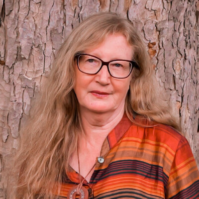 Diana Powell is a white woman with long fair hair. She is wearing a top which is striped red and orange and is wearing glasses.