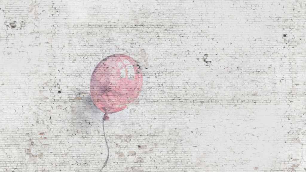 Photo of a single baby pink balloon painted on a white bright wall