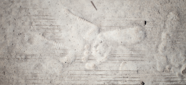 Faint outline of footprints in cement.