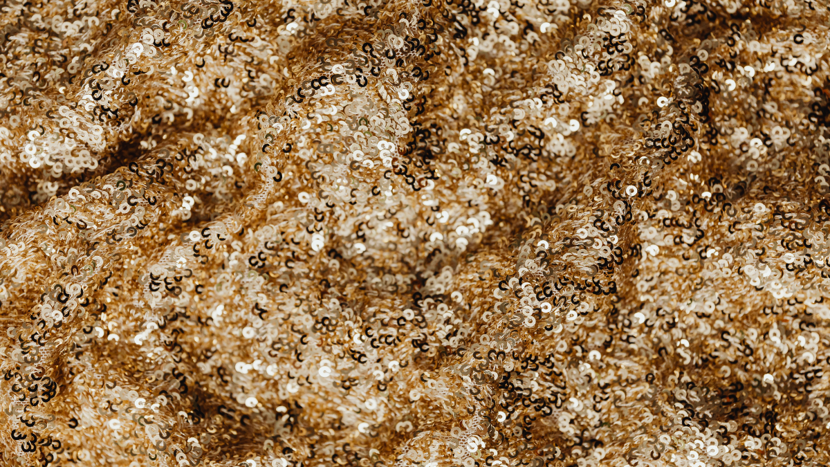 Close up photo of sparkling gold sequinned fabric