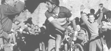 This cover shows a colour photograph of cyclist Gina Bartali riding through a cheering crowd.
