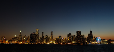 Photo of a city skyline lit up against the dark night sky