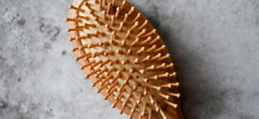 A wooden hairbrush laying on a grey worktop