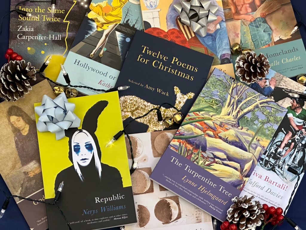 Photograph of lots of Seren poetry titles including Republic, Twelve Poems for Christmas and The Turpentine Tree lying in a scattered pile surrounded by festive decorations.