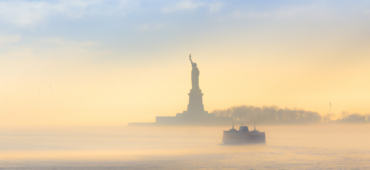 Photo of the statue of liberty surrounded by morning mist.