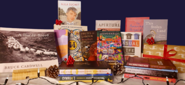 A group of Seren titles arranged against a snowy blanket surrounded by festive lights