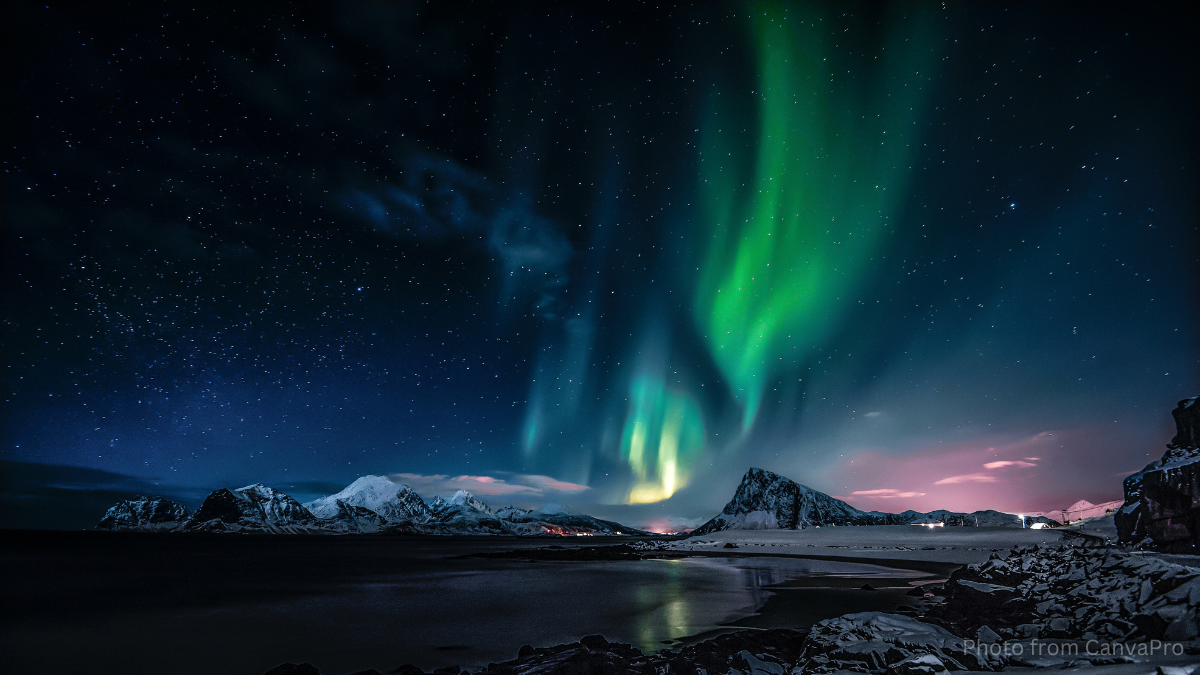 The green smudge of the Northern Lights hanging over an icy lake and lonely mountain.