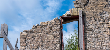 Photo depicting the ruined wall and empty window of a crumbling building