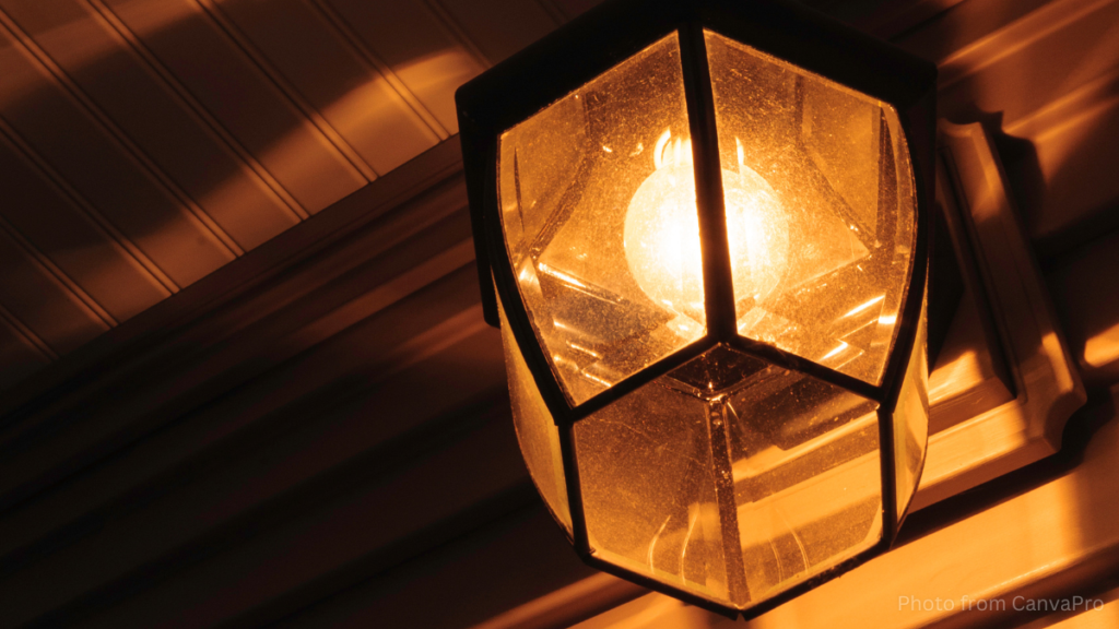 Close-up photo of a glass porch light shining in the dark.