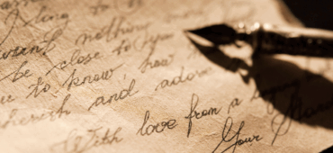 Close up picture of cursive writing on aged paper.