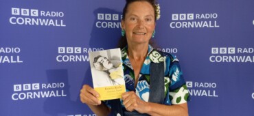Photo of Katrina Naomi holding up a copy of her book taken at BBC Radio Cornwall.