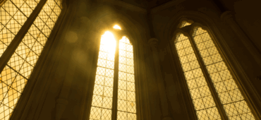 Photo showing sunlight streaming through the imposing windows of a church.