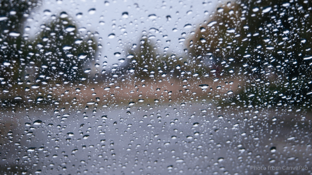 Close up photo of raindrops on a window blurring the view outside