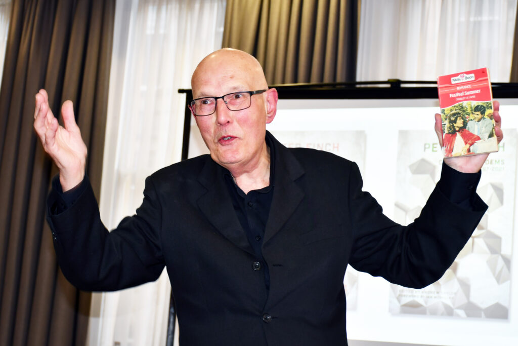Photo of Peter Finch talking animatedly at the launch of his collected poems.