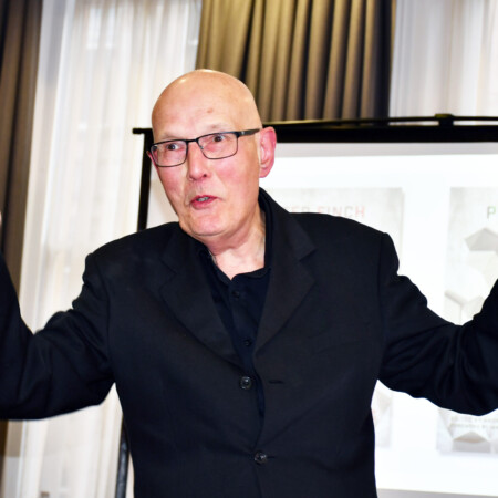 Photo of Peter Finch talking animatedly at the launch of his collected poems.